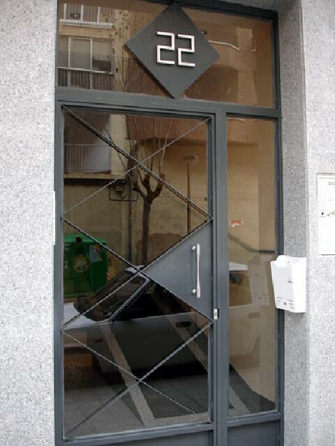 Puerta de  diseño modernista conjuntada con varios tamaños romboidales.